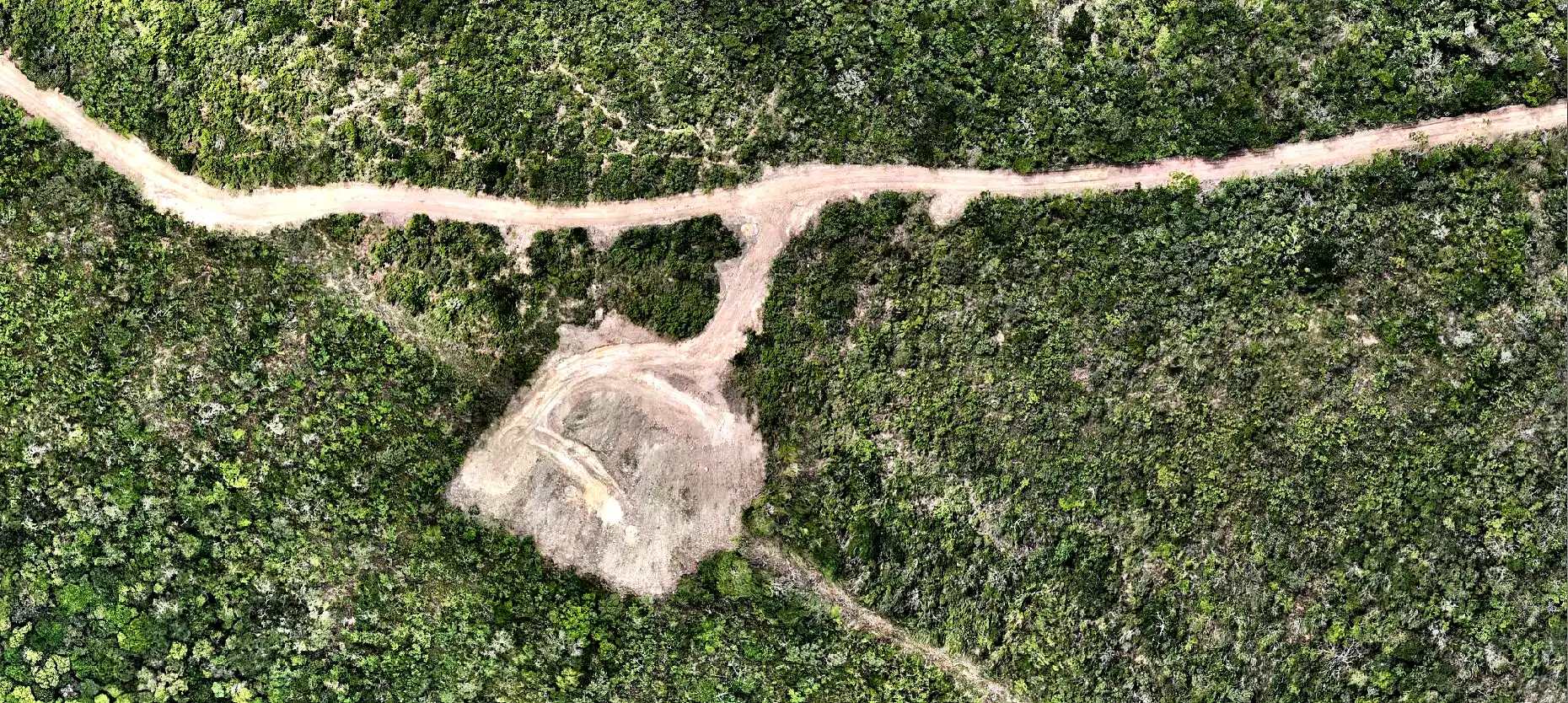 Vista aérea da mesma área depois da supressão: estrada de acesso aberta e praça da torre no lugar da vegetação.